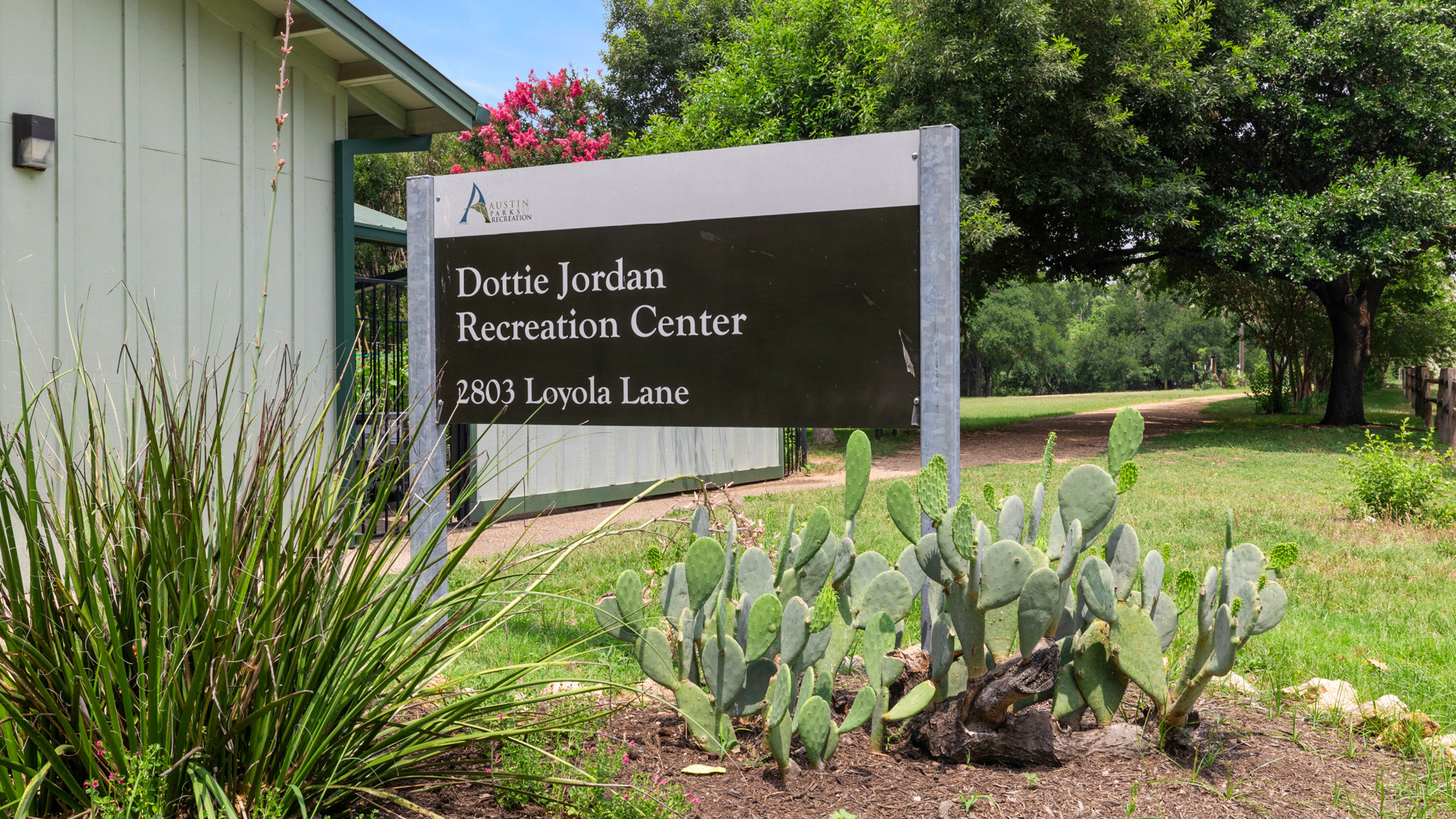 Dottie Jordan Recreation Center sign behind landscaping grass and cactus.